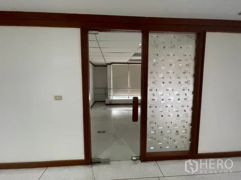 办公空间 出租在Khlong Toei, Bangkok - 木框入口与磨砂玻璃面板通向办公室套间