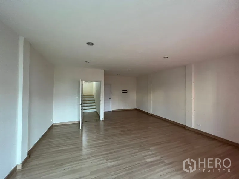 Home Office for rent or sale - Wide office room with wood flooring and access to stairwell, ideal for meeting space.