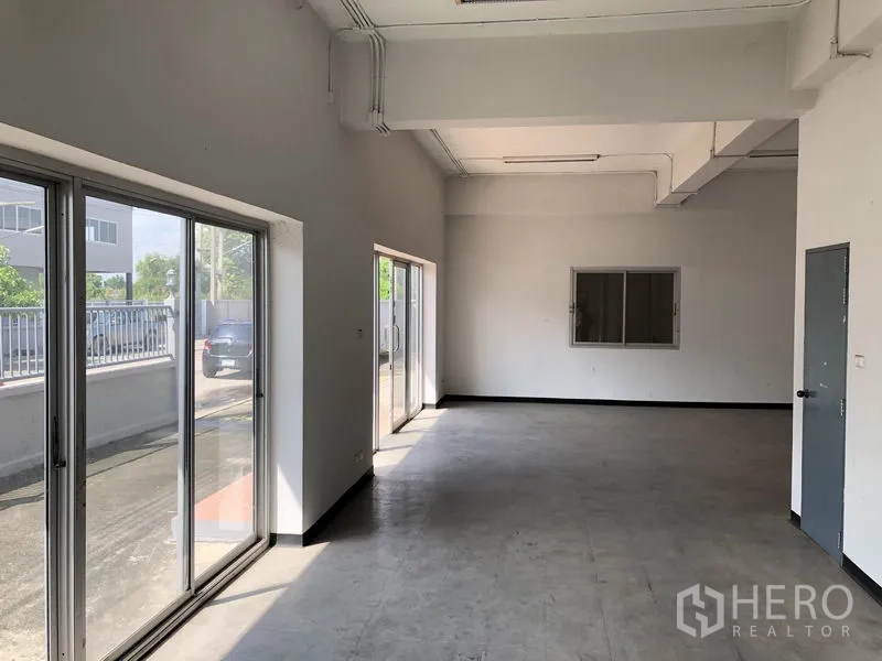 Factory for rent in Pathum Thani - Ground-floor office or showroom with sliding glass doors opening to the driveway.