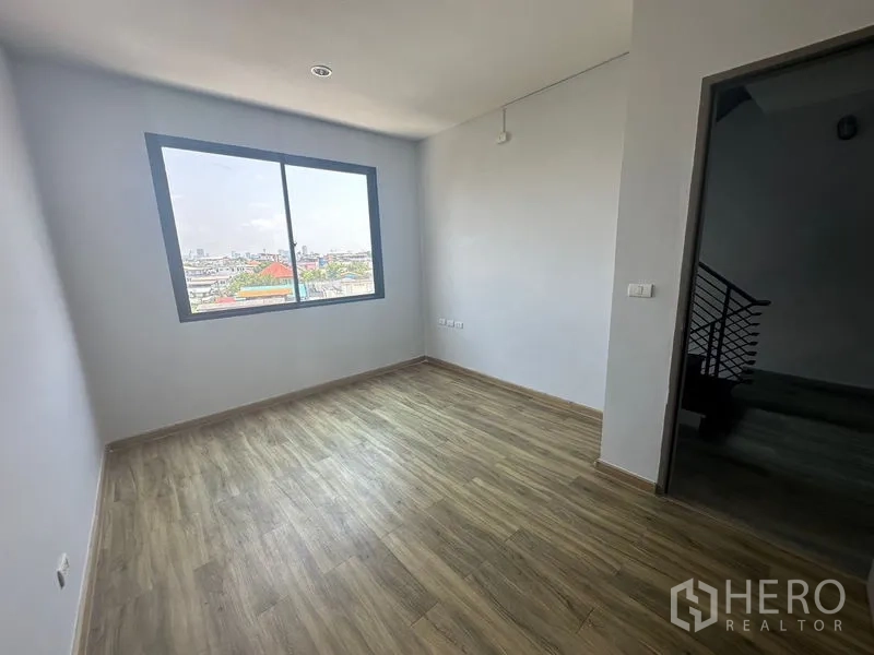 Home Office for rent - Bright bedroom or office with city view through a sliding window and wood floors.