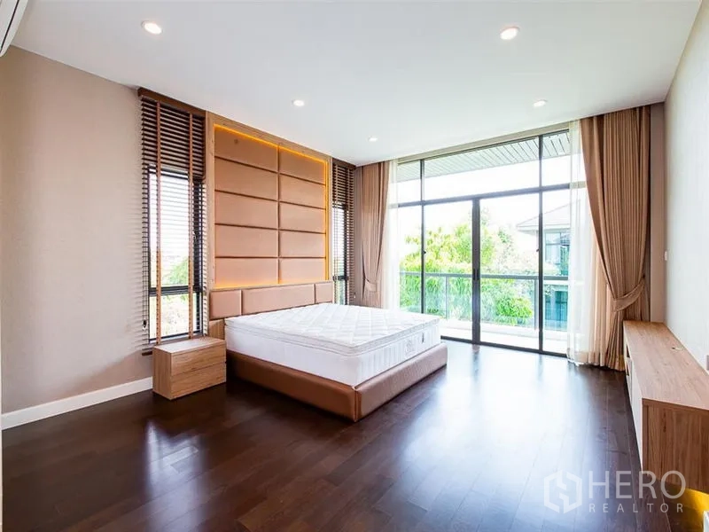 Detached House for rent or sale in Prawet, Bangkok - Spacious master bedroom with balcony access and floor-to-ceiling windows.