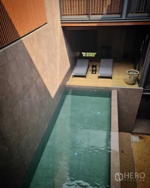 บ้าน ขายในLat Phrao, Bangkok - ภาพมุมสูงสระว่ายน้ำแคบยาวและดาดไม้พร้อมเตียงอาบแดด