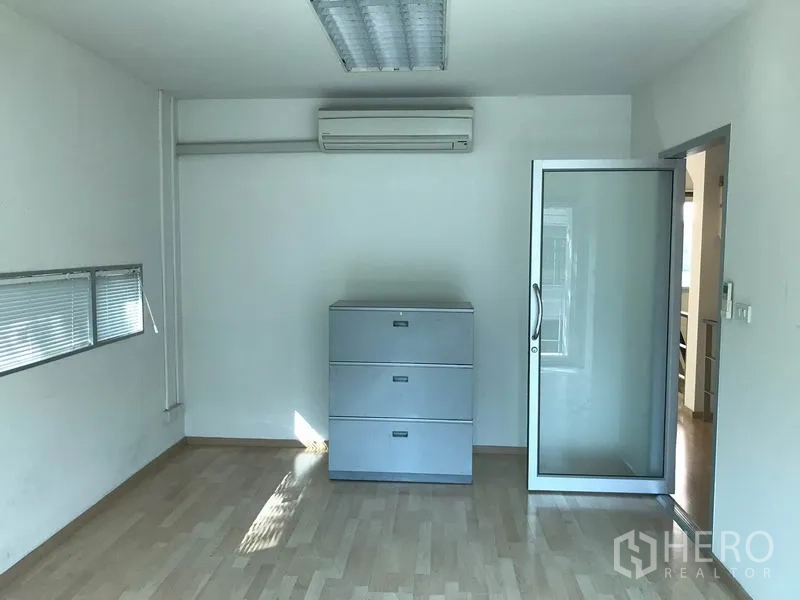 Townhouse for rent in Suan Luang, Bangkok - Multi-purpose room with air conditioner, glass door and laminate flooring.