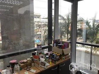办公空间 出租在Khlong Toei, Bangkok - 转角落地窗带城市景观与台面存放办公用品。