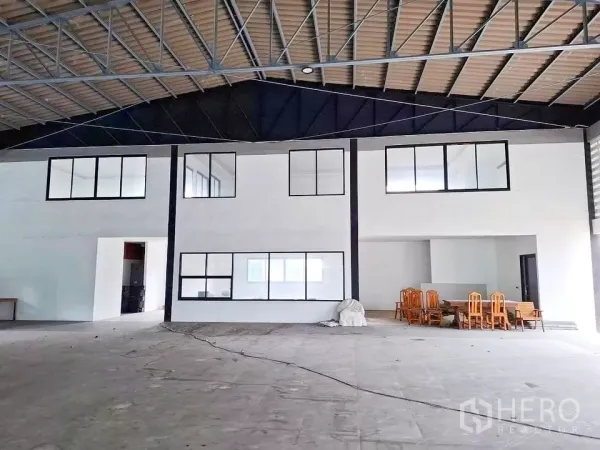 Warehouse for rent in Bang Kapi, Bangkok - High-clearance interior featuring a steel truss roof and a built-in two-storey office block.