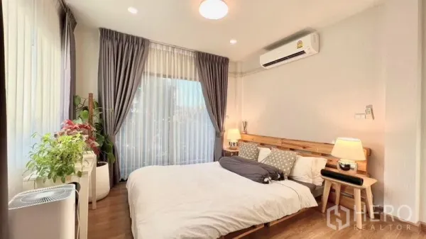 บ้าน ให้เช่าหรือขายในBang Khen, Bangkok - ห้องนอนสว่าง เตียงไม้ เครื่องปรับอากาศ หน้าต่างบานใหญ่ และต้นไม้ในบ้าน