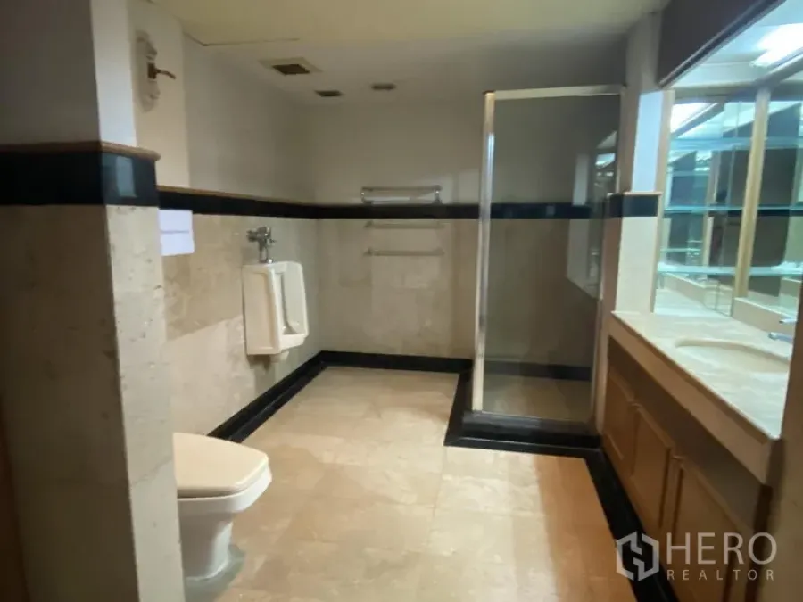 Office Space for rent in Din Daeng, Bangkok - Spacious office bathroom with tiled floors, glass shower, vanity and urinal.