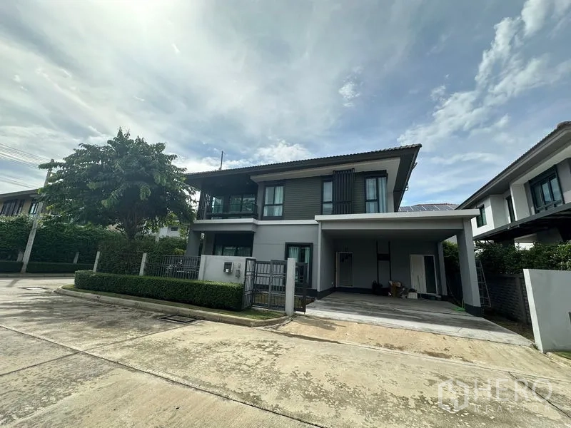 Detached House for rent in Lam Luk Ka, Pathum Thani - Front exterior showing large covered two-car carport and driveway.