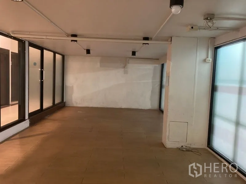 Retail Space for rent in Khlong Toei, Bangkok - Long rectangular sales floor with track lighting and glass walls on two sides.