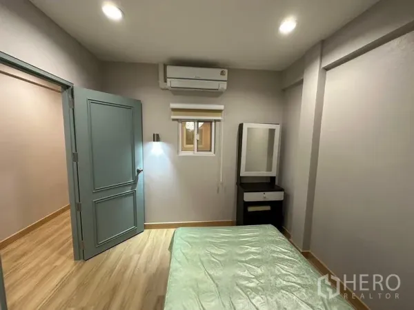 联排别墅 出租在Phra Khanong, Bangkok - 温馨卧室带单人床、梳妆台、空调与柔和照明。