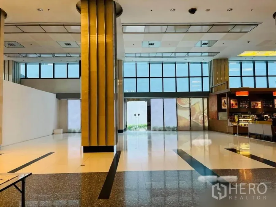 Retail Space for rent in Khlong Toei, Bangkok - Retail space frontage facing a glass entry with tall windows and a neighboring coffee shop.