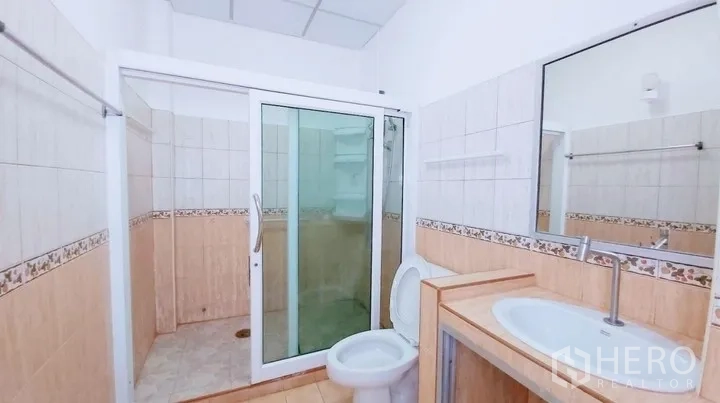Townhouse for sale - Bathroom with glass-enclosed shower, vanity and toilet.