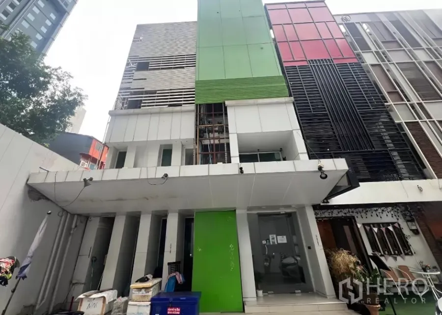 Shophouse for sale in Watthana, Bangkok - Multi-storey shophouse facade with green panels and glass entrance in a prime Phrom Phong location.
