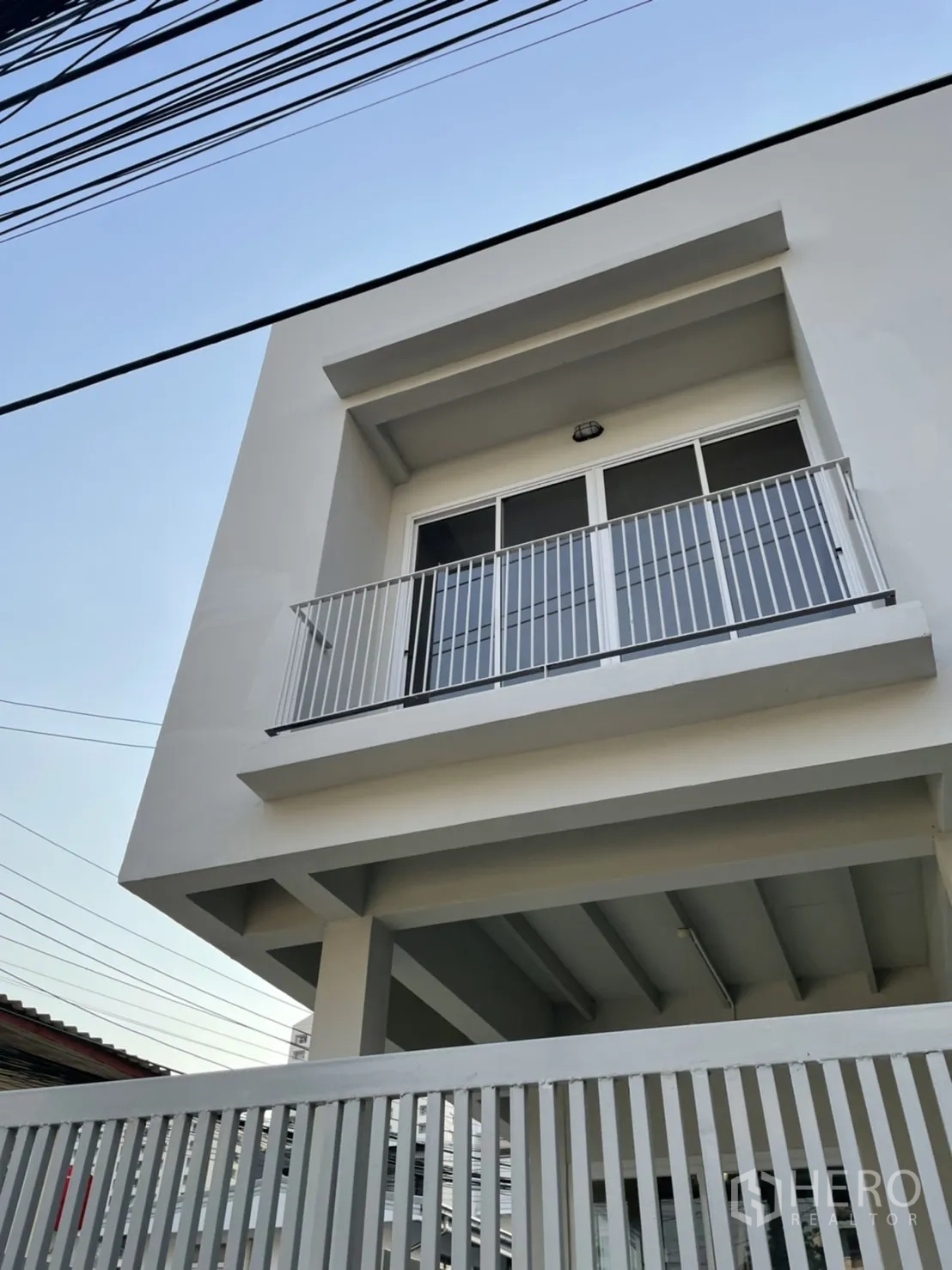 Detached House for rent or sale in Din Daeng, Bangkok - Close view of upper-floor balcony and metal railing on the white house exterior.