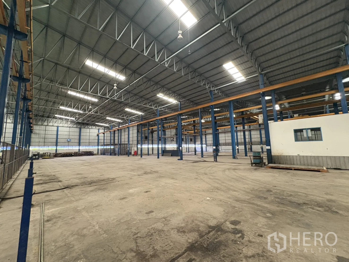 Factory for rent in Phra Pradaeng, Samut Prakan - Open storage area inside the factory with polished concrete floor.