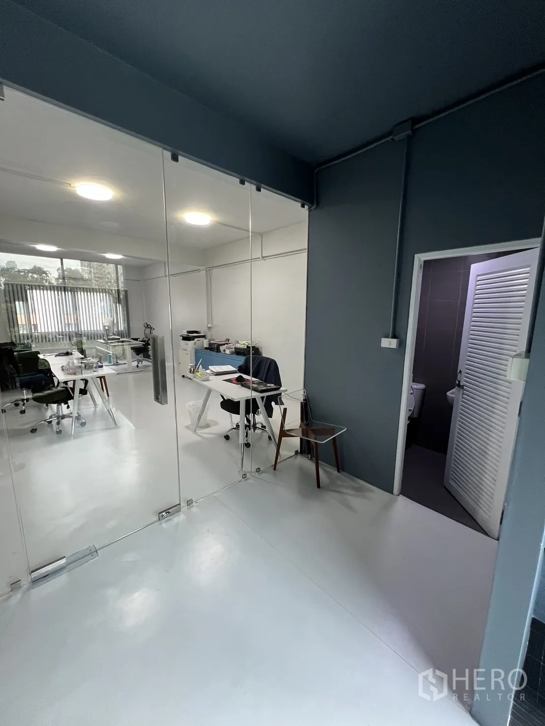 Shophouse for rent or sale in Watthana, Bangkok - Corridor with glass partition leading to a white office and a door to the restroom.