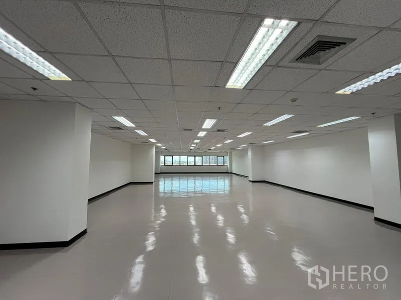 Office Space for rent or sale - Open office area featuring central air vents, grid ceiling, and natural light from full-length windows.