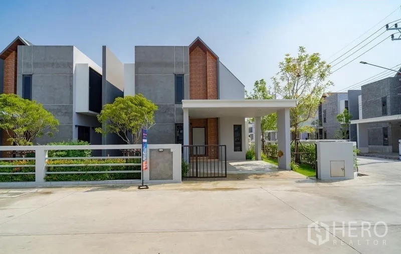 Detached House for sale in Lam Luk Ka, Pathum Thani - Street view of the home with covered carport and gated entrance.