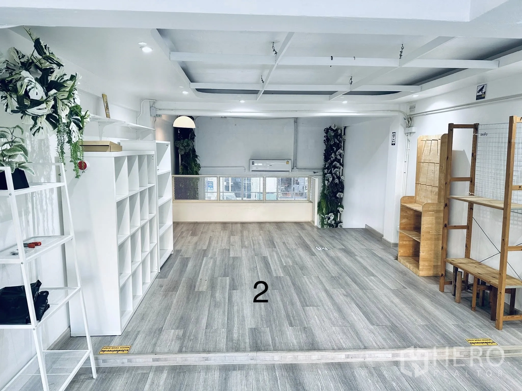 Shophouse for rent in Watthana, Bangkok - Another view of the open-plan level showing shelving units, wooden fixtures, and plants.