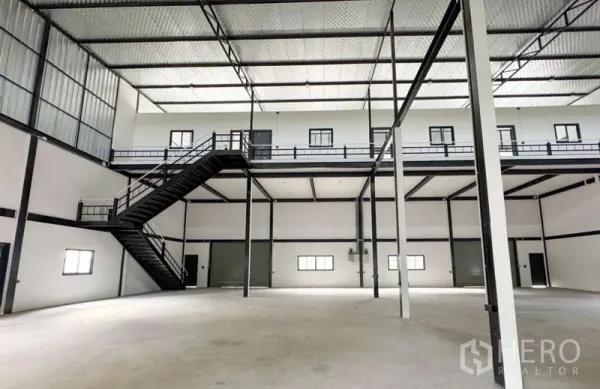Warehouse for rent in Bang Phli, Samut Prakan - Mezzanine level with metal staircase, walkways and multiple internal loading doors.