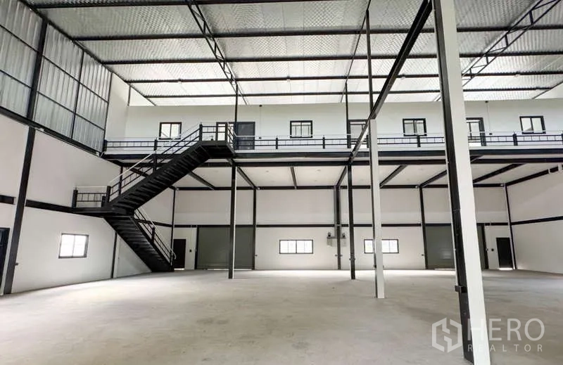 Warehouse for rent in Bang Phli, Samut Prakan - Mezzanine level with metal staircase, walkways and multiple internal loading doors.
