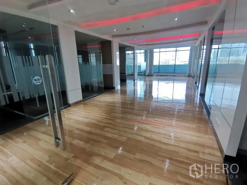 Office Space for rent in Bang Rak, Bangkok - Entrance corridor with glass doors leading to a spacious workspace and red cove lighting.