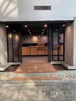 Retail Space for rent in Khlong Toei, Bangkok - Wide shop entrance featuring sliding glass doors, wooden counters, and polished concrete walls.
