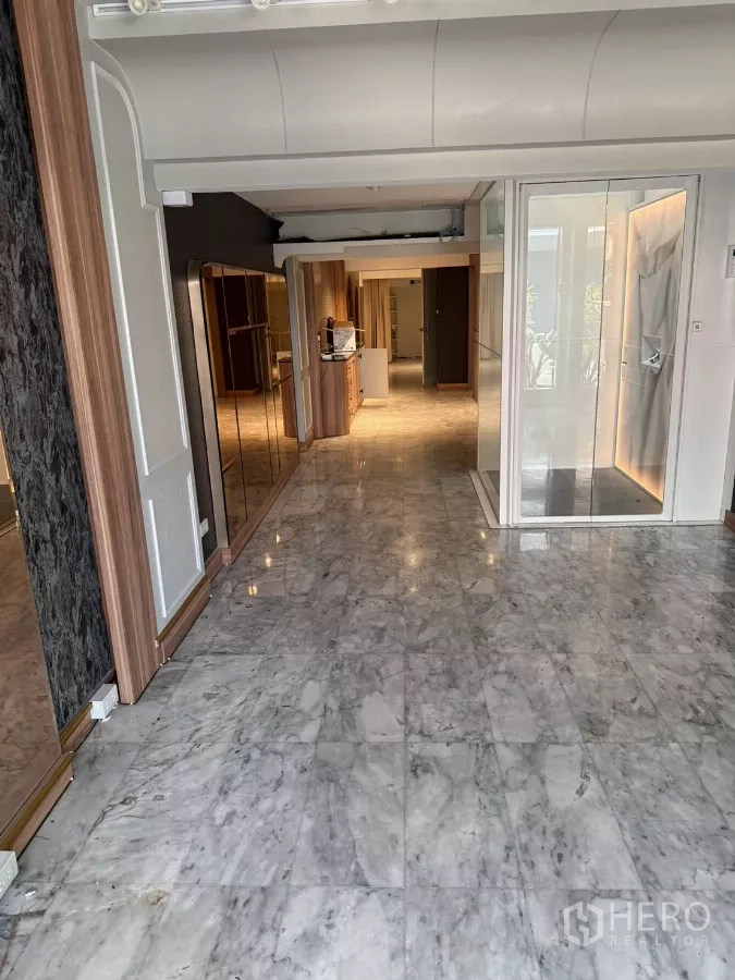 Shophouse for rent - Ground-floor interior with polished marble tiles, glass entry, and built-in wood cabinetry.
