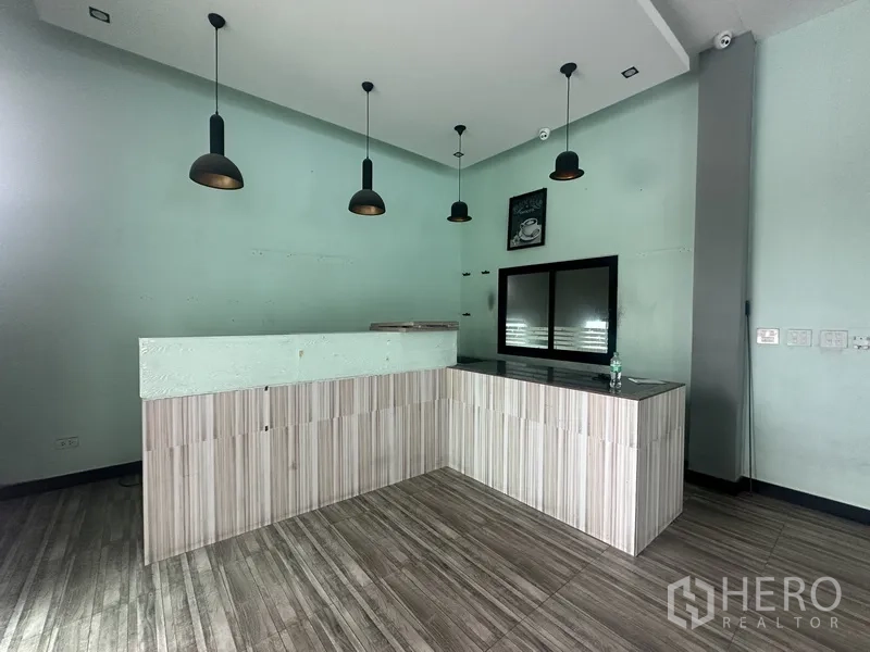 Standalone for rent in Prawet, Bangkok - Reception or service counter with pendant lighting in a mint-green room.