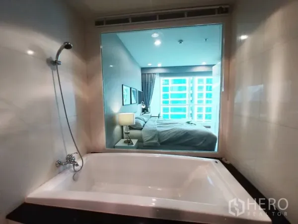 Condominium for rent in Pathum Wan, Bangkok - Modern bathroom with large soaking tub and picture window looking into the master bedroom.