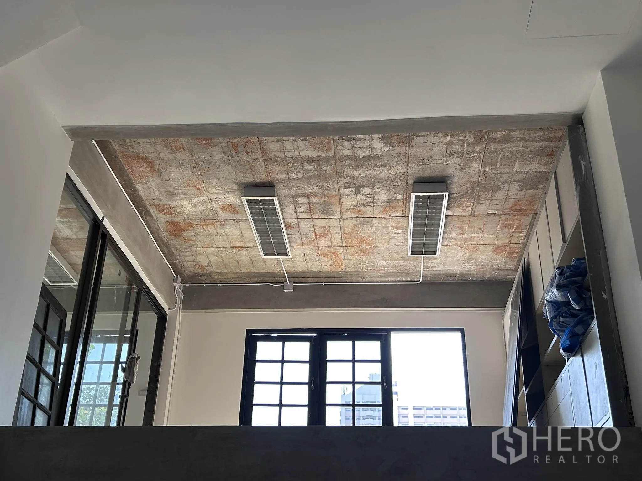 Home Office for rent or sale in Watthana, Bangkok - Exposed concrete ceiling detail with fluorescent light fixtures.