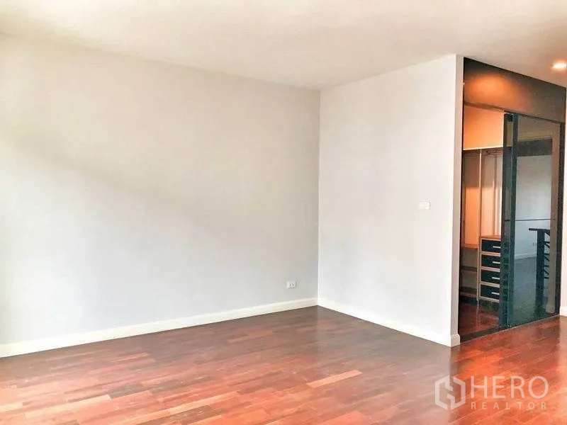 Townhouse for rent in Watthana, Bangkok - Bedroom or multipurpose room with walk-in closet behind tinted glass.