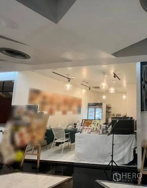 Retail Space for rent in Watthana, Bangkok - Bright retail interior with white ceiling, pendant globe lights, track lighting, cafe-style seating, and a compact service counter.