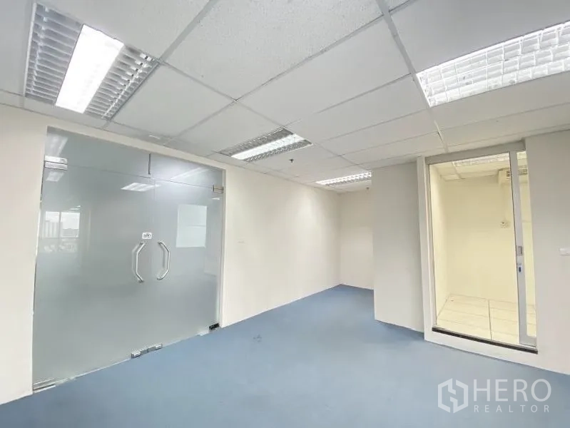 办公空间 出租在Chatuchak, Bangkok - 明亮办公室，吊顶灯具、磨砂双开玻璃门与蓝色地毯。