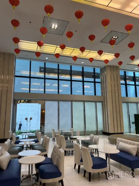 Retail Space for rent in Khlong Toei, Bangkok - Bright retail lobby with lounge seating, round tables, floor-to-ceiling windows and festive red lanterns overhead in Khlong Toei.