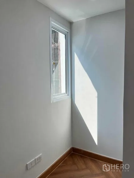 Townhouse for sale in Phra Khanong, Bangkok - Bright corner with a single window casting light onto wood-look flooring.