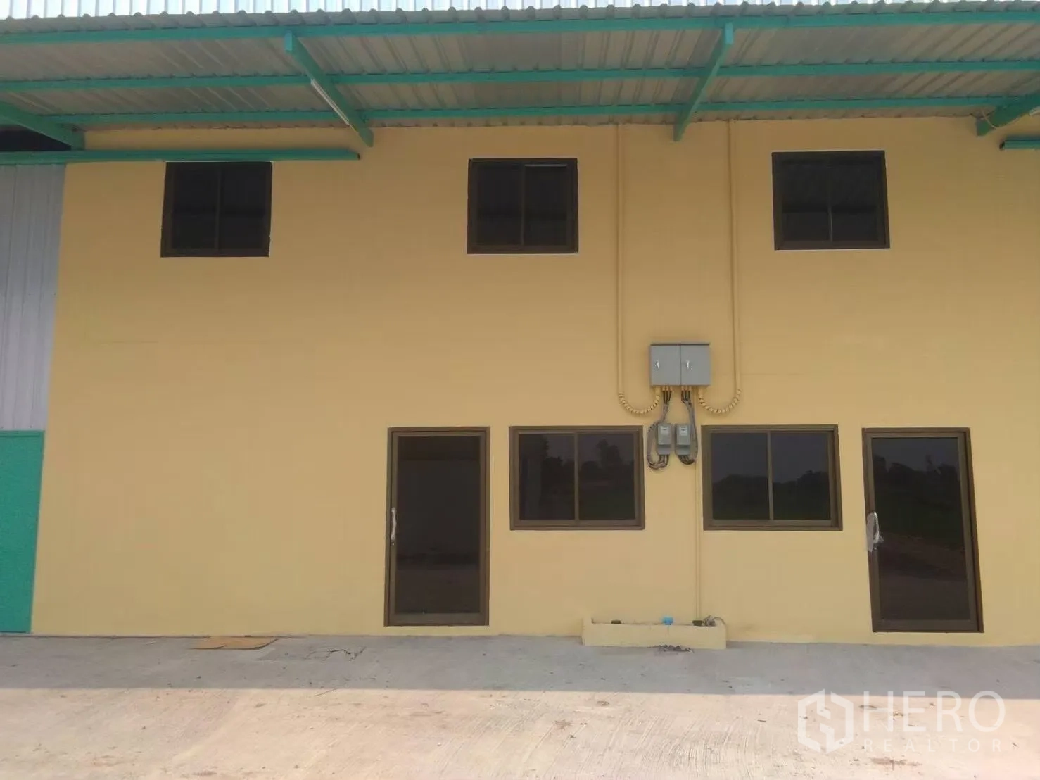 Factory for rent in Khlong Luang, Pathum Thani - Two-storey factory facade with windows and a covered canopy.