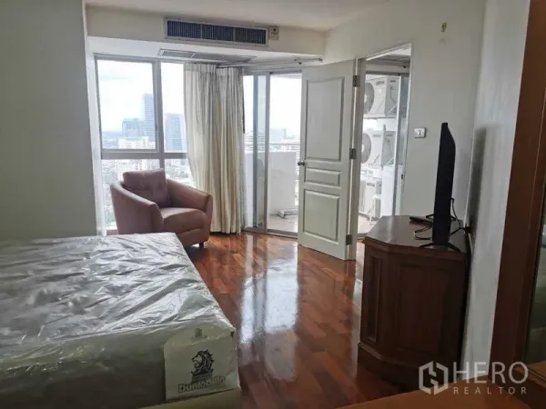 Condominium for rent - Bright bedroom with armchair and sliding doors to a balcony with city views.