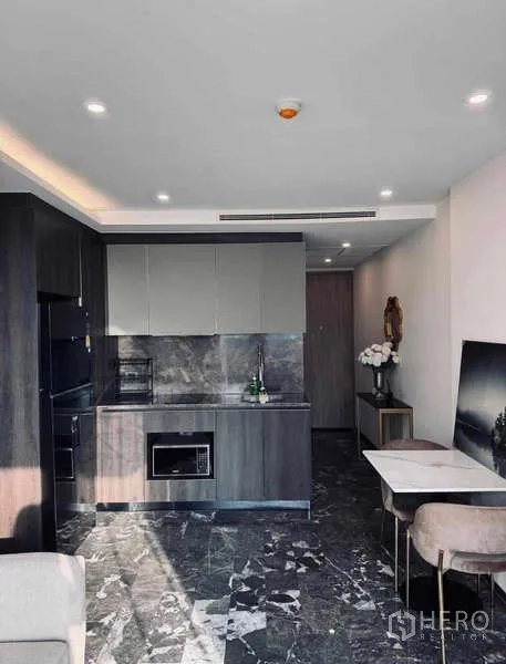 Condominium for rent in Khlong Toei, Bangkok - Compact kitchen with built-in cabinets, microwave and marble flooring.