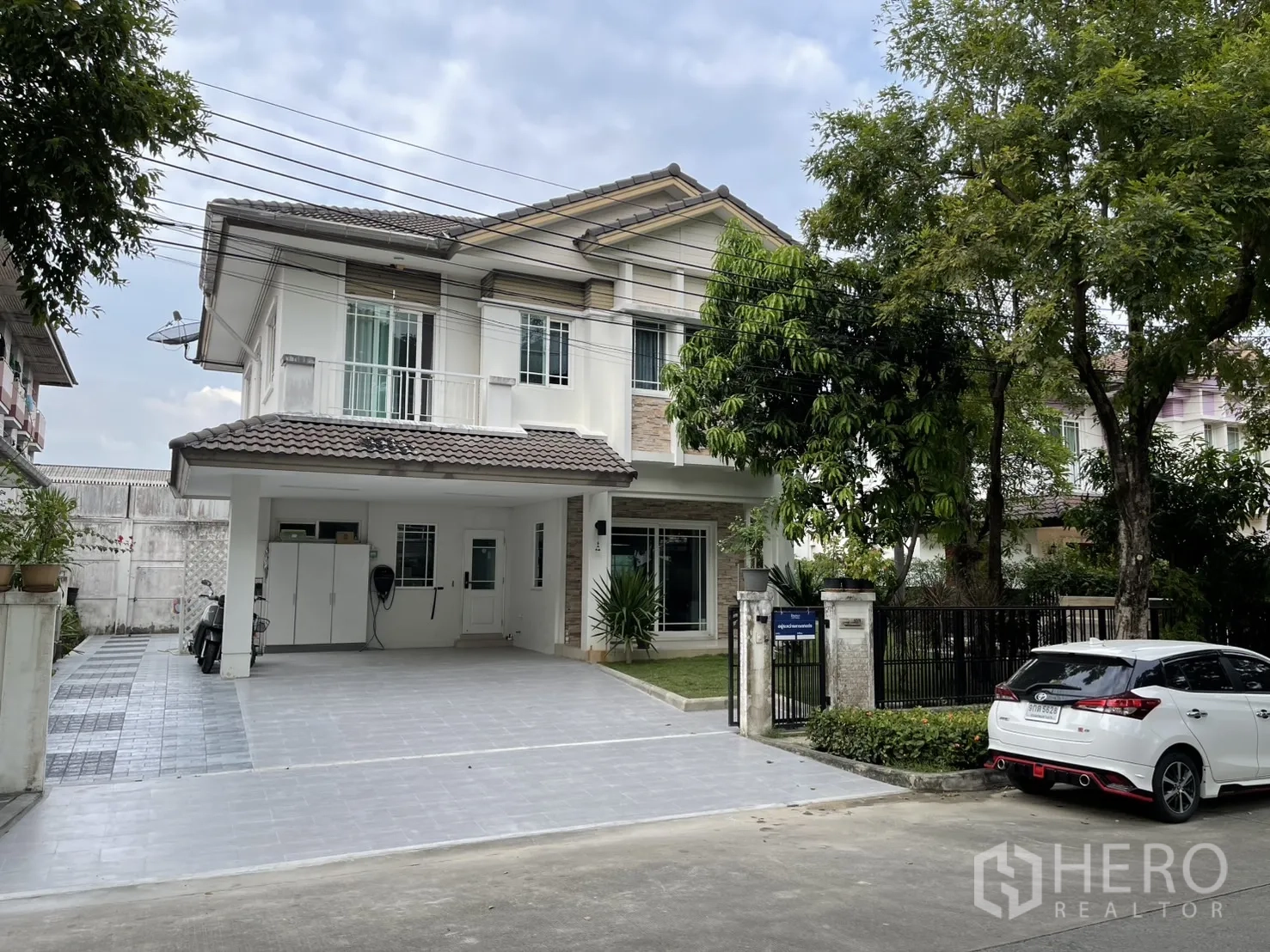 Detached House for rent in Bang Kapi, Bangkok - Two-storey detached house with gated driveway and covered carport beneath mature trees in Bang Kapi.