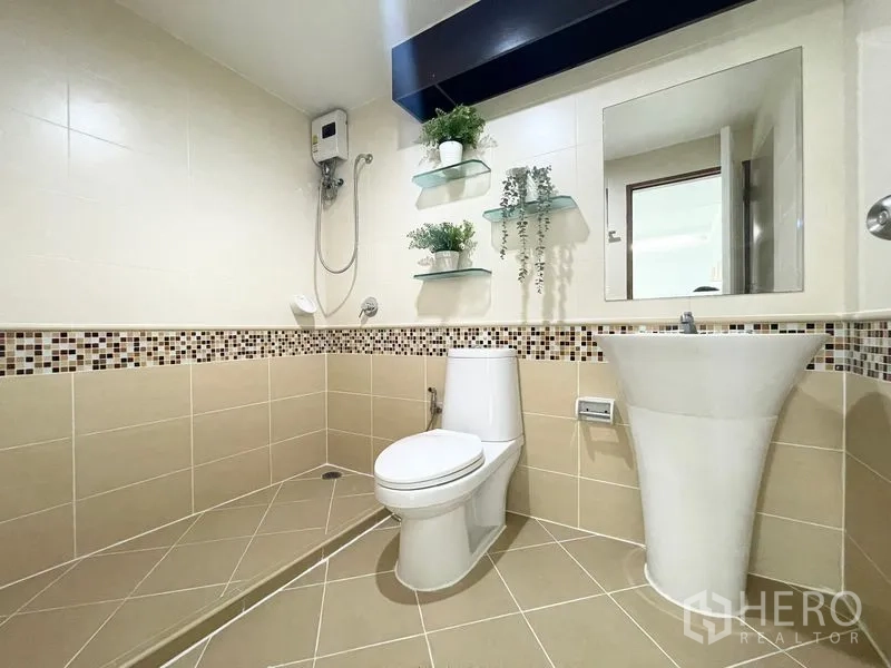 Condominium for rent in Khlong Toei, Bangkok - Bathroom with walk-in shower, pedestal sink, toilet, and glass shelves.