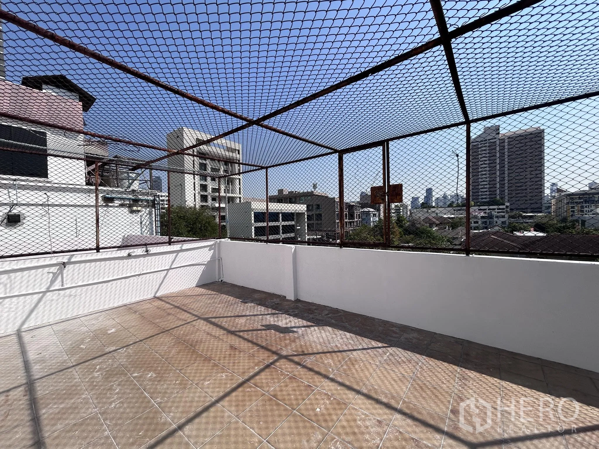 Home Office for rent or sale in Watthana, Bangkok - Rooftop terrace with safety netting and skyline views of Bangkok.
