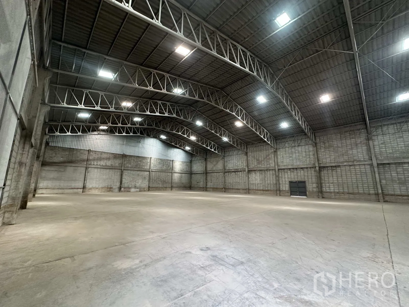 Warehouse for rent in Phra Nakhon Si Ayutthaya - Interior hall with curved truss roof and block walls under skylights.
