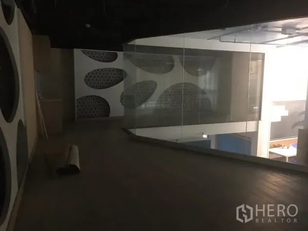 Retail Space for rent in Khlong Toei, Bangkok - Mezzanine level with glass railing overlooking an open retail floor and abstract wall art.