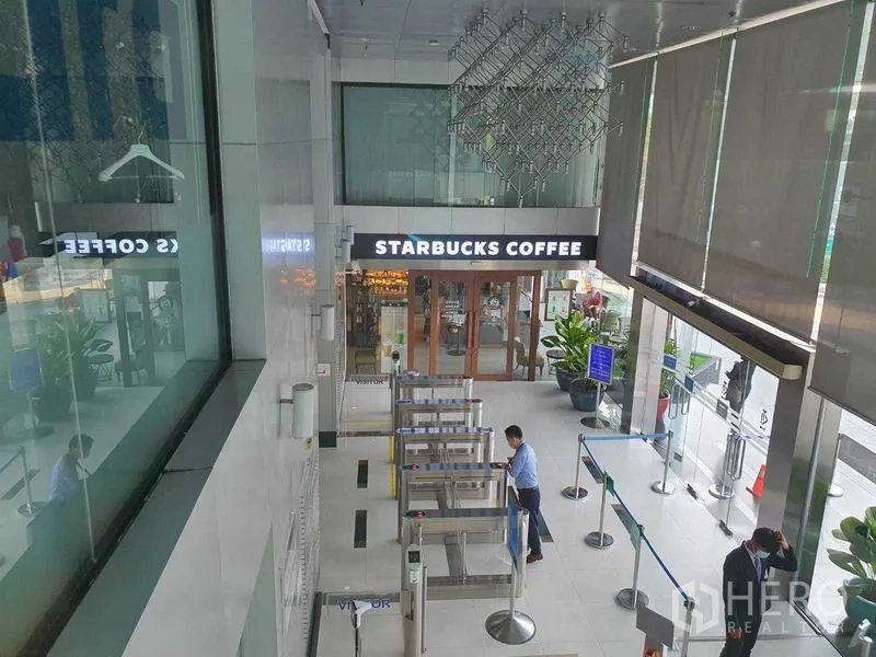 Office Space for rent in Ratchathewi, Bangkok - Building lobby with secure turnstiles and a coffee shop at the entrance.