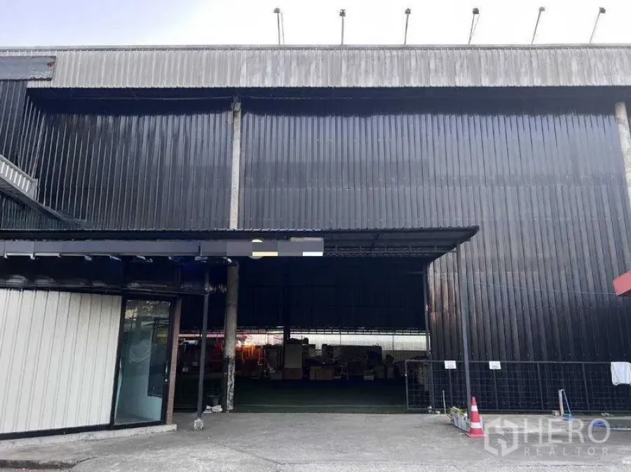 Warehouse for rent in Lat Phrao, Bangkok - Facade of the black corrugated-metal warehouse with a wide entrance.