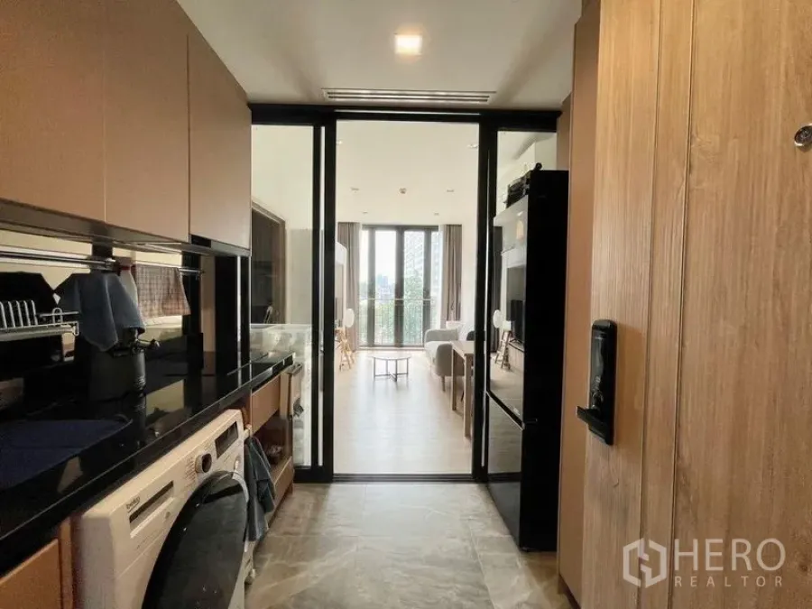 公寓 出租或出售在Watthana, Bangkok - 厨房走廊望向客厅与阳台，玻璃移门通透开阔。