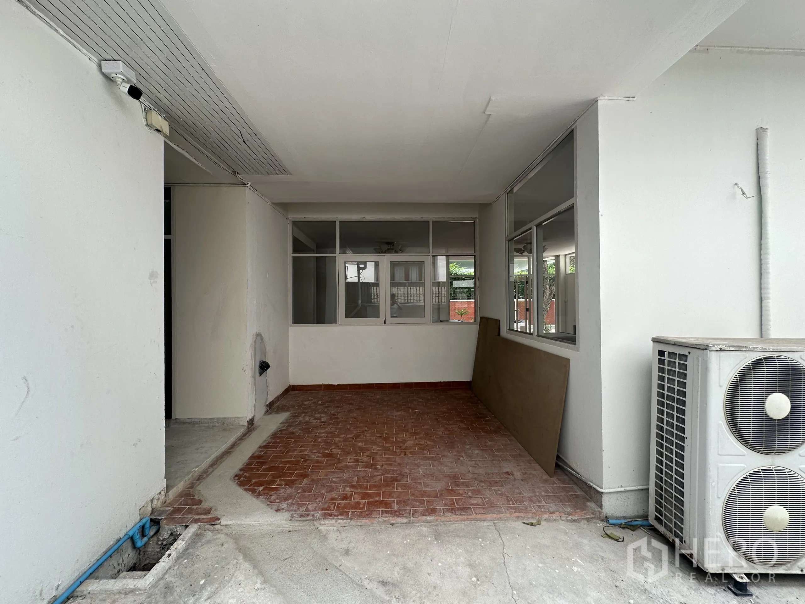带办公室的家 出租在Watthana, Bangkok - 有顶棚的红砖地露台，外机组可见，通往室内。