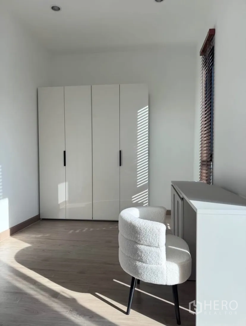 Detached House for rent in Samut Prakan - Another view of the study or bedroom with wardrobe and white accent chair.