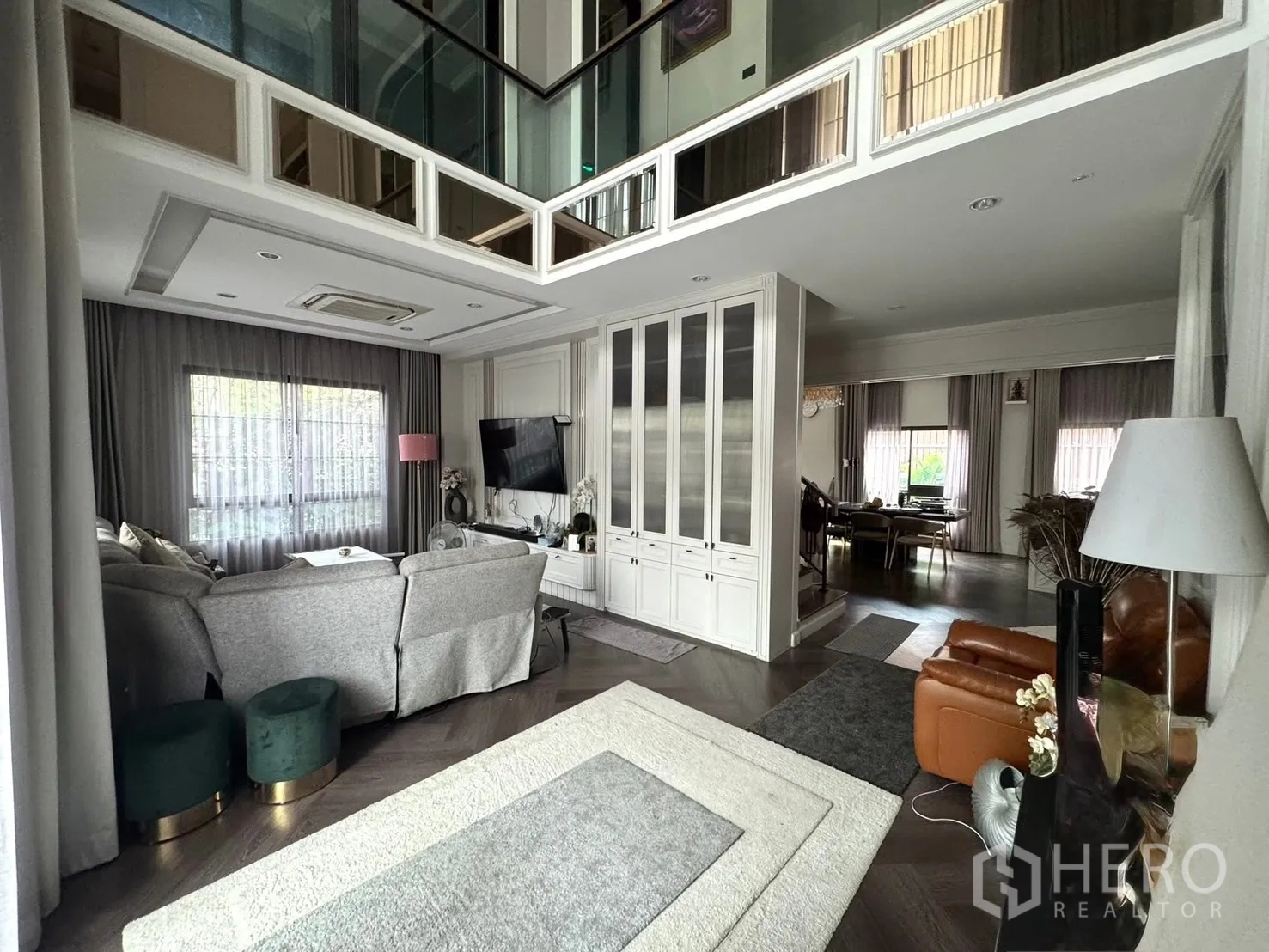 Detached House for sale in Mueang Pathum Thani, Pathum Thani - Living area connected to dining room with large windows and soft curtains.